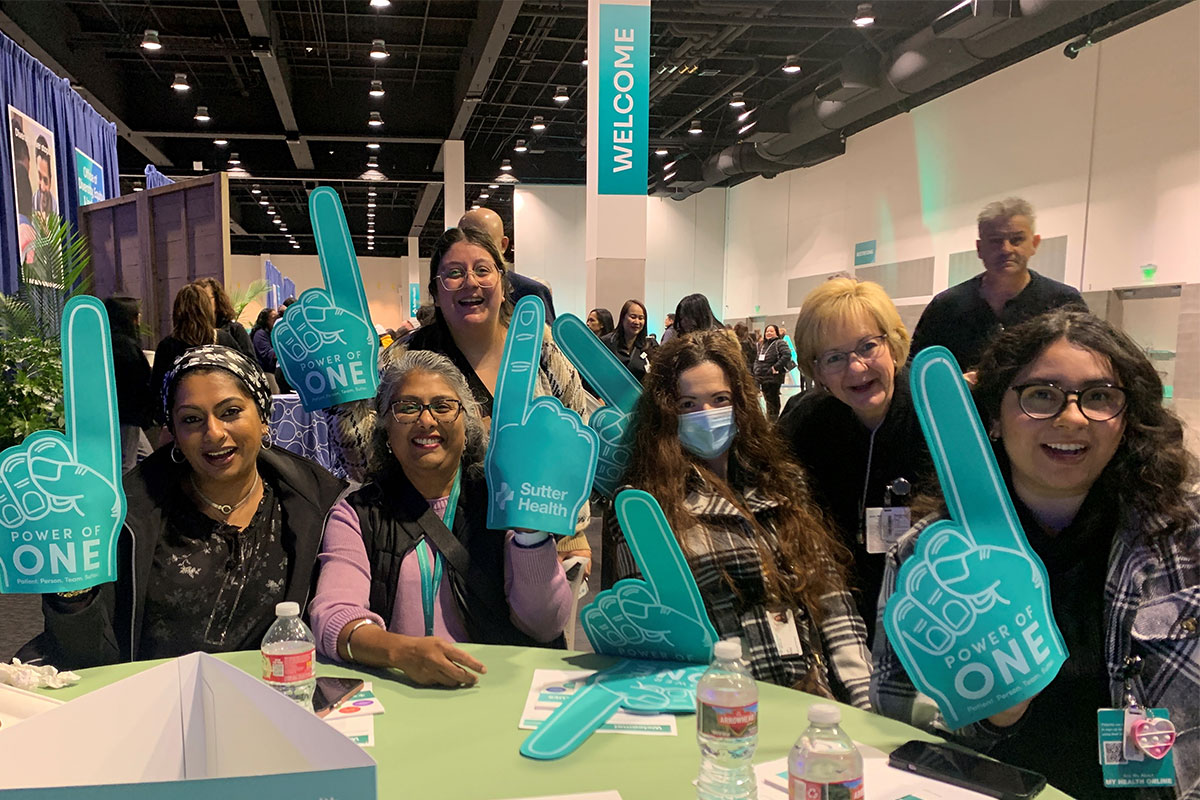 A group of women at a convention holding signs advocating for various causes.